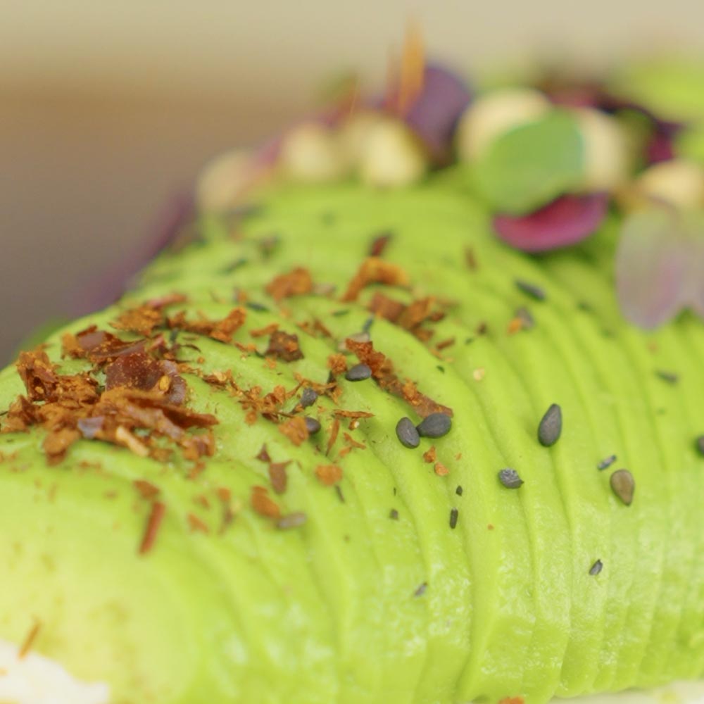 Frisch geriebene Chilliflocken auf einem Avocado-Baguette
